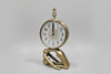 Decorative wall clock with gold hands and detailed face on a white wall.