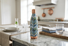Decorative water bottle on a kitchen counter with a modern kitchen background